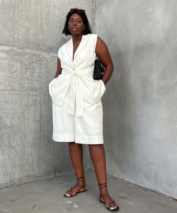 Nicole Omuteku - colete e bermuda com sandália rasteira - sandálias confortáveis - Verão - em frente a uma parede - https://stealthelook.com.br