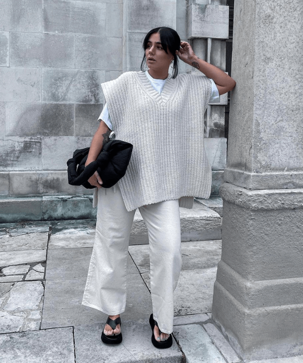 Grace Surguy - calça jeans, t-shirt branca e colete de tricô - peças oversized - verão - em pé na rua - https://stealthelook.com.br
