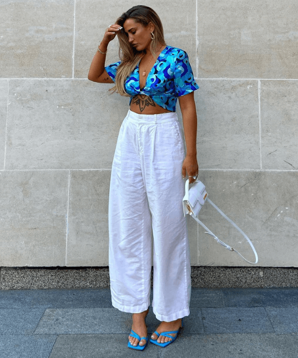 Faye Mills - calça branca e cropped azul - sandália neon - Verão - em pé na rua - https://stealthelook.com.br