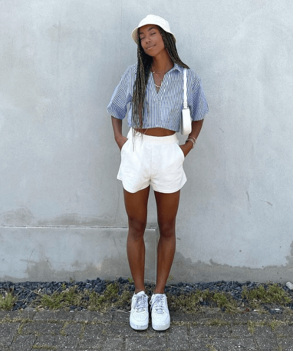Amaka Hameliknck - shorts branco e camisa cropped listrada azul - festas de fim de ano - Verão - em pé na rua - https://stealthelook.com.br