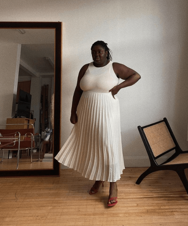 Abisola Omole - saia plissada e blusa off white - modelos de saia - Verão - em pé na casa  - https://stealthelook.com.br