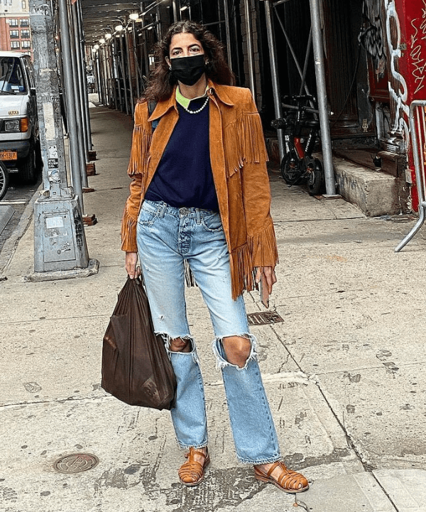 Leandra Cohen - calça jeans, sandálias e jaqueta de franjas caramelo - tendência dos anos 70 - Outono - em pé na rua - https://stealthelook.com.br
