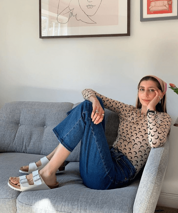 Poppy Almond - calças, papetes e blusa estampada - tendências de moda - verão - sentada em um sofá - https://stealthelook.com.br