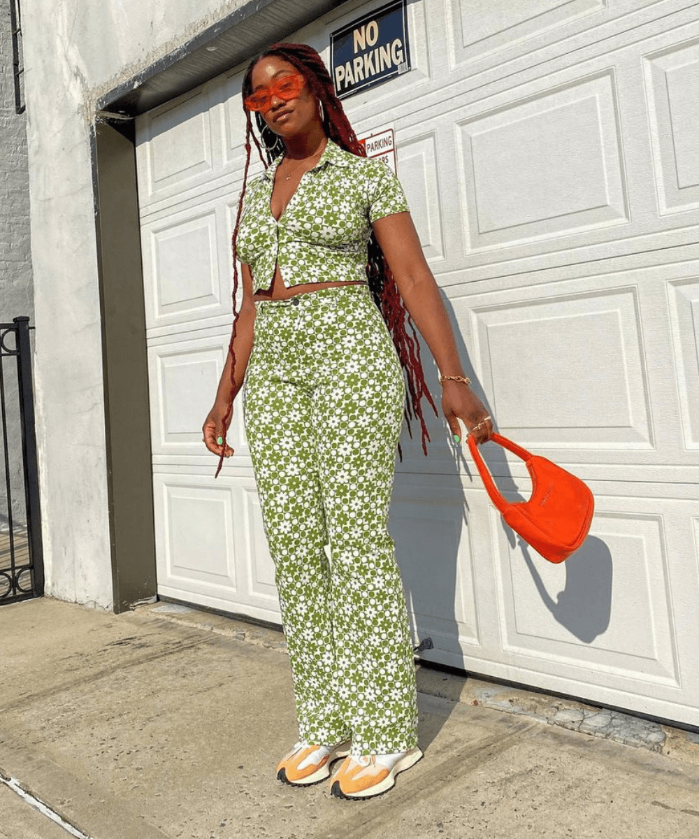 Yolande Macon - conjunto de calça e cropped estampados e bolsa laranja - looks novos - Verão - em pé na rua - https://stealthelook.com.br