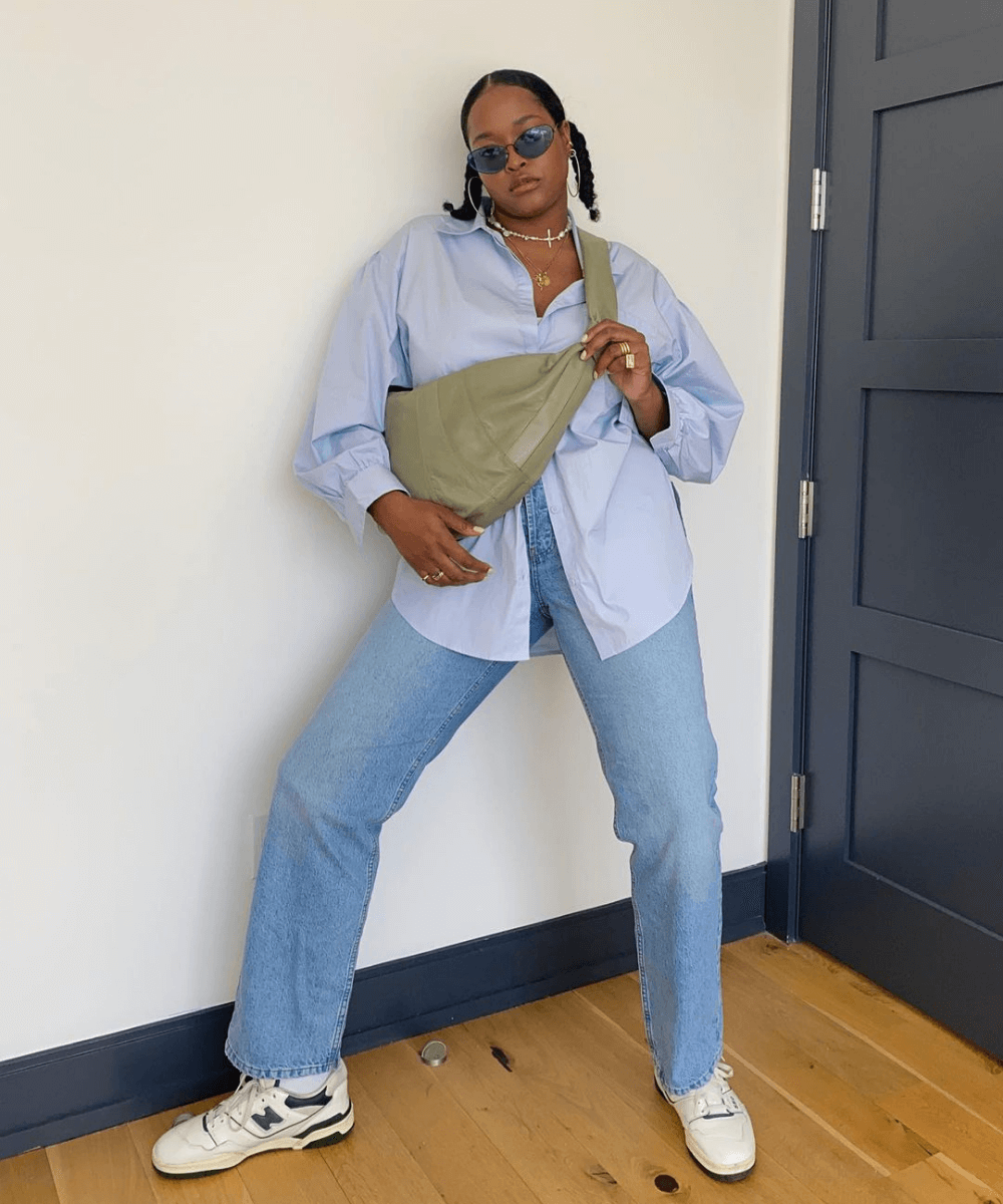 Imani Randolph - calça jeans e camisa social azul com tênis - looks novos - verão - em pé na casa  - https://stealthelook.com.br