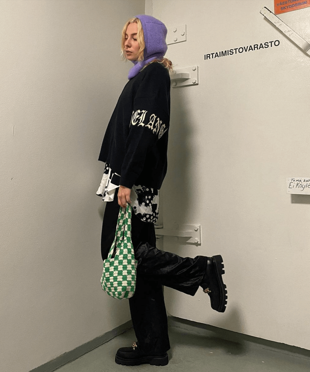 Henrietta Harju - camisa e moletom com calça preta e balaclava - Balaclava - Inverno 2022 - em frente a porta de metal - https://stealthelook.com.br