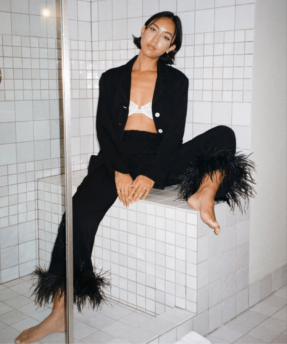 Stephanie Arant - conjunto preto com calça de plumas - tendências de moda - Outono - sentada em um banco - https://stealthelook.com.br