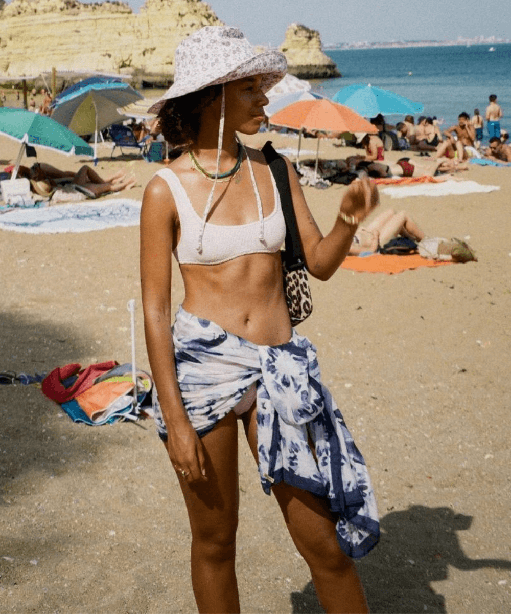 Fiah Hameliknck - biquíni, canga e chapéu - moda praia - verão - em pé na praia - https://stealthelook.com.br