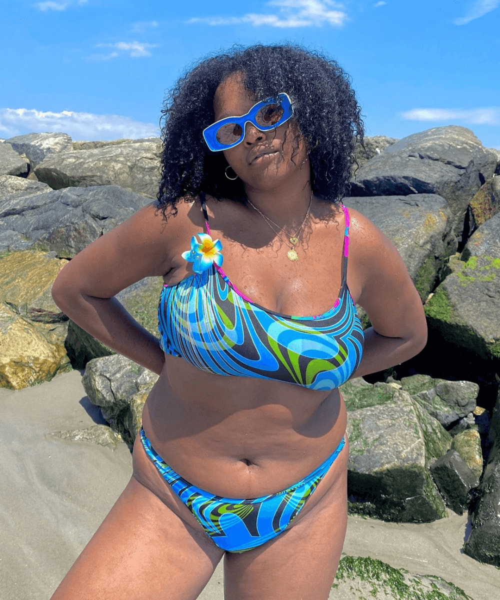 Imani Randolph - biquíni colorido e óculos azul - moda praia - verão - em pé na praia - https://stealthelook.com.br