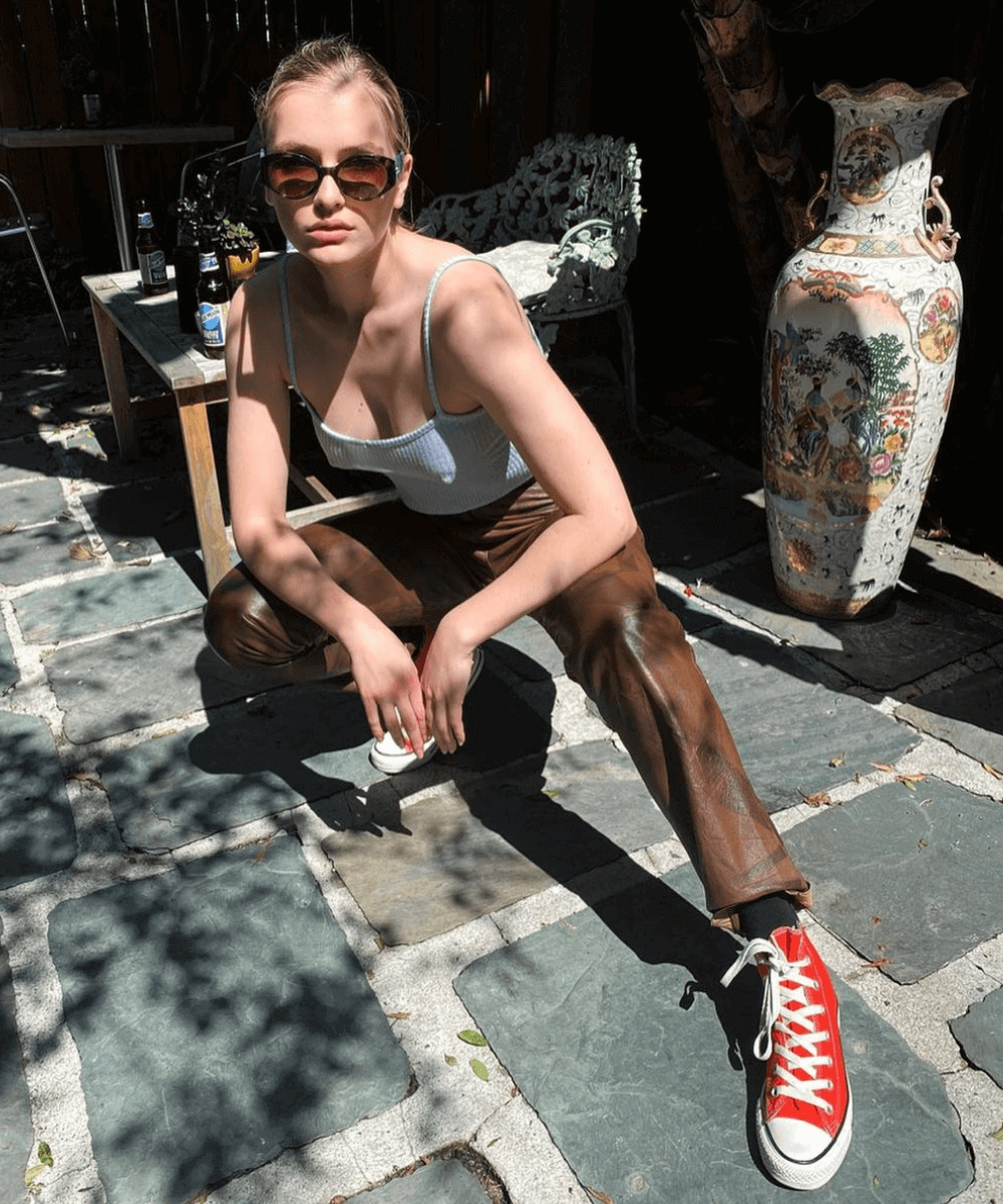 Camille Razat - calça de p.u marrom, regata e converse vermelho - Camille Razat - verão - sentada na rua - https://stealthelook.com.br