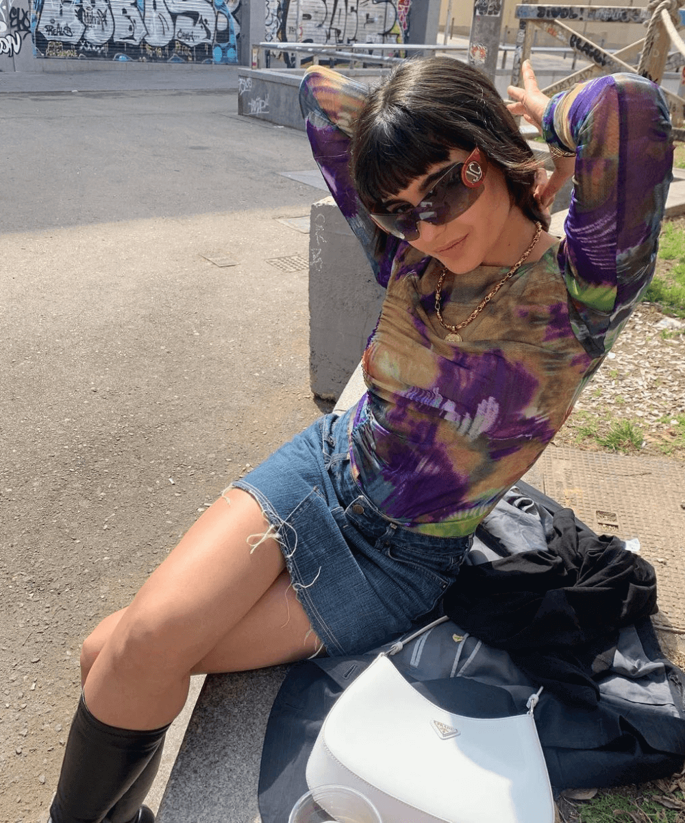 María Bernard - minissaia jeans e blusa segunda pele - looks com saia jeans - verão - sentada na rua - https://stealthelook.com.br