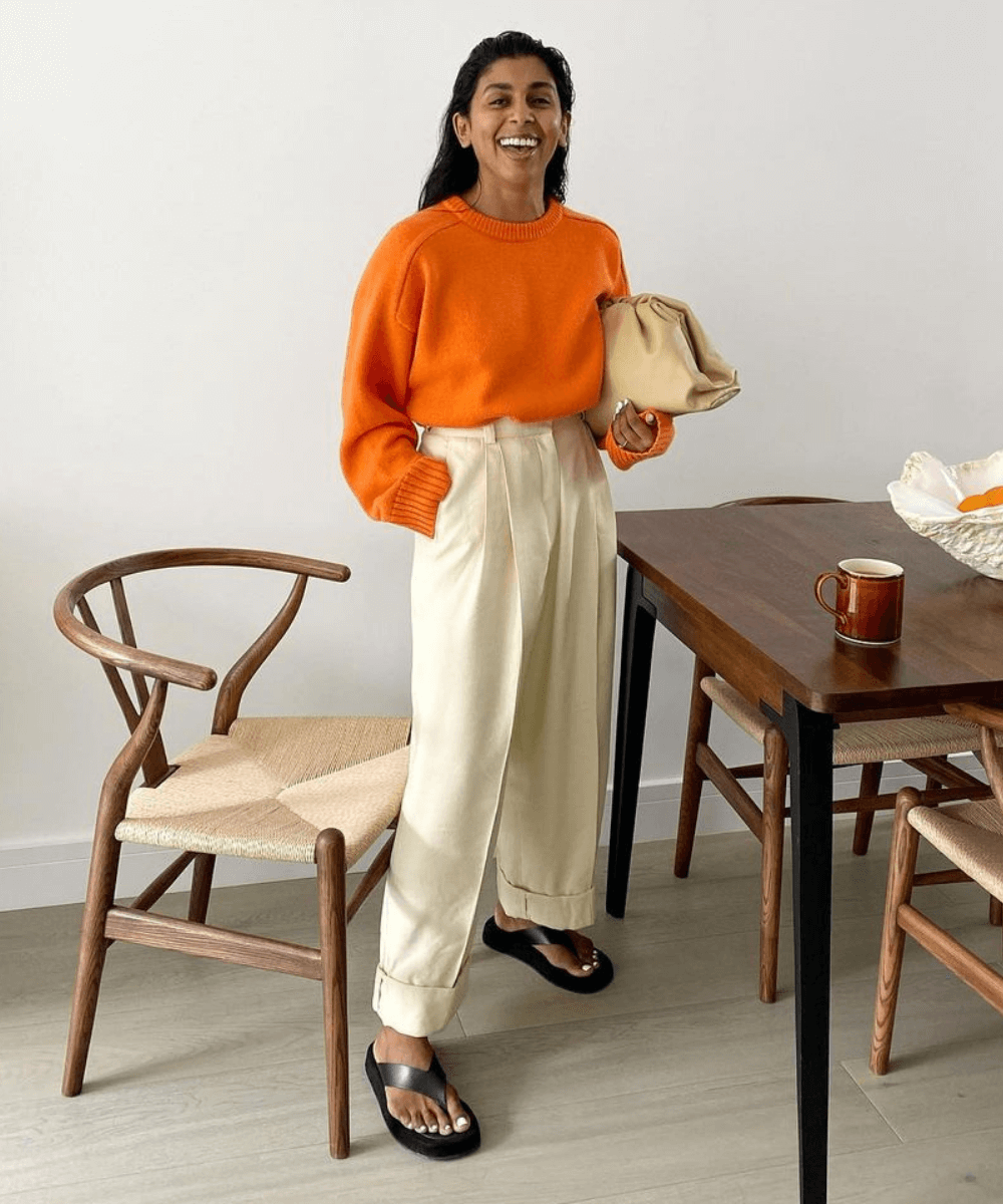 Monikh - calça de alfaiataria bege, tricot laranja e chinelos - looks básicos - Outono - em pé na casa  - https://stealthelook.com.br