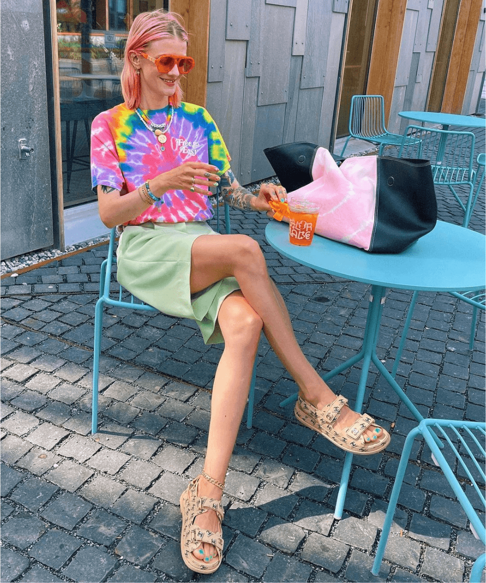 Marianne Theodorsen - camiseta tie dye com short e papete - sapatos confortáveis - Verão 2022 - sentada no restaurante - https://stealthelook.com.br