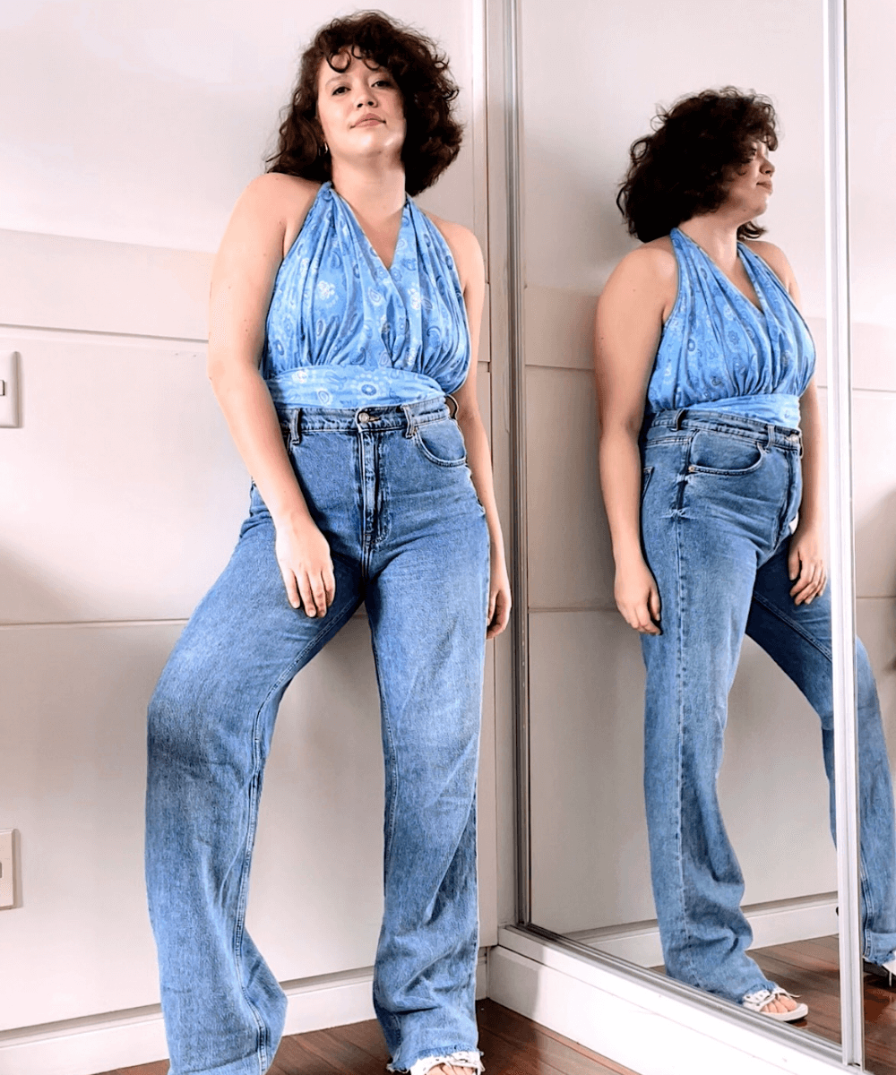 Ligia Xavier - calça jeans e canga azul como blusa - canga de praia - verão - em pé na casa  - https://stealthelook.com.br