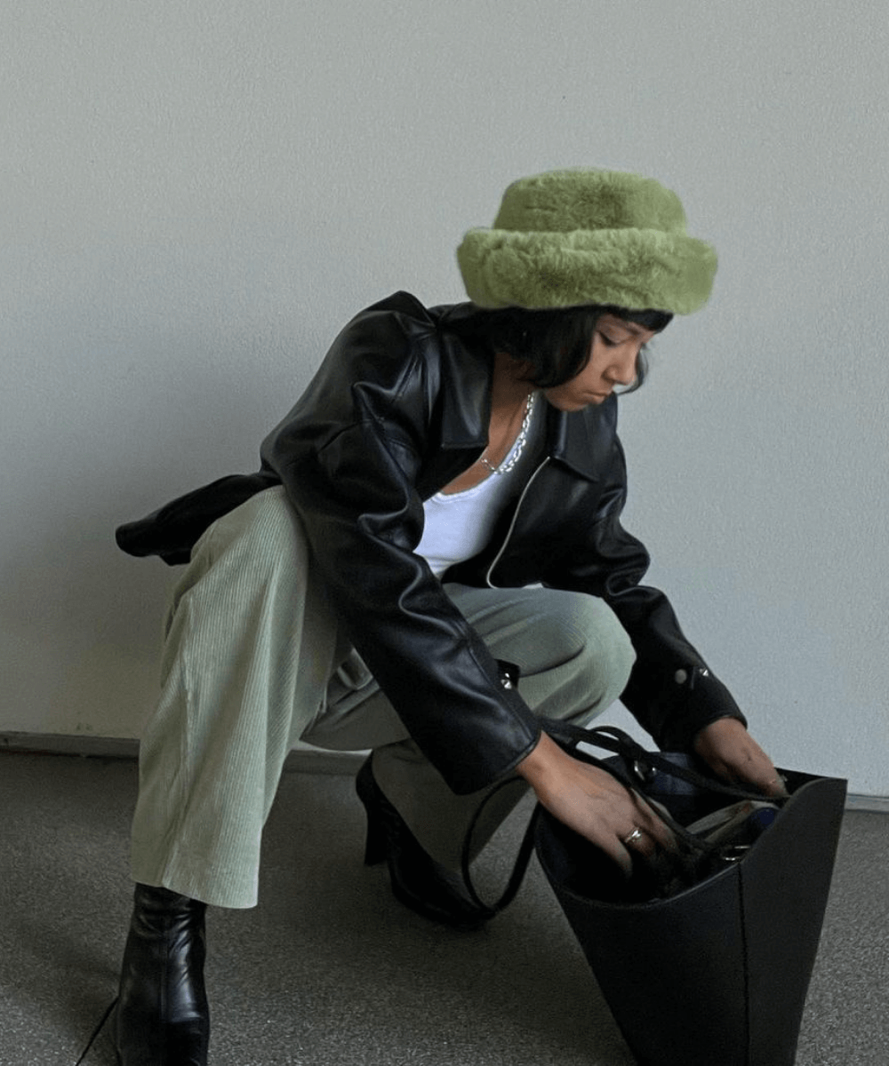 Stephanie Arant - calça verde, botas e jaqueta de couro - casacos de inverno - Inverno  - agachada em frente a uma parede - https://stealthelook.com.br
