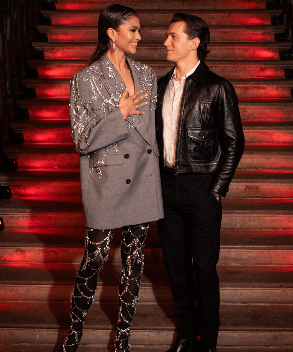 Zendaya e Tom Holland - blazer com adereços e meia-calça brilhante - Valentine's Day - Inverno  - em pé perto da escada - https://stealthelook.com.br