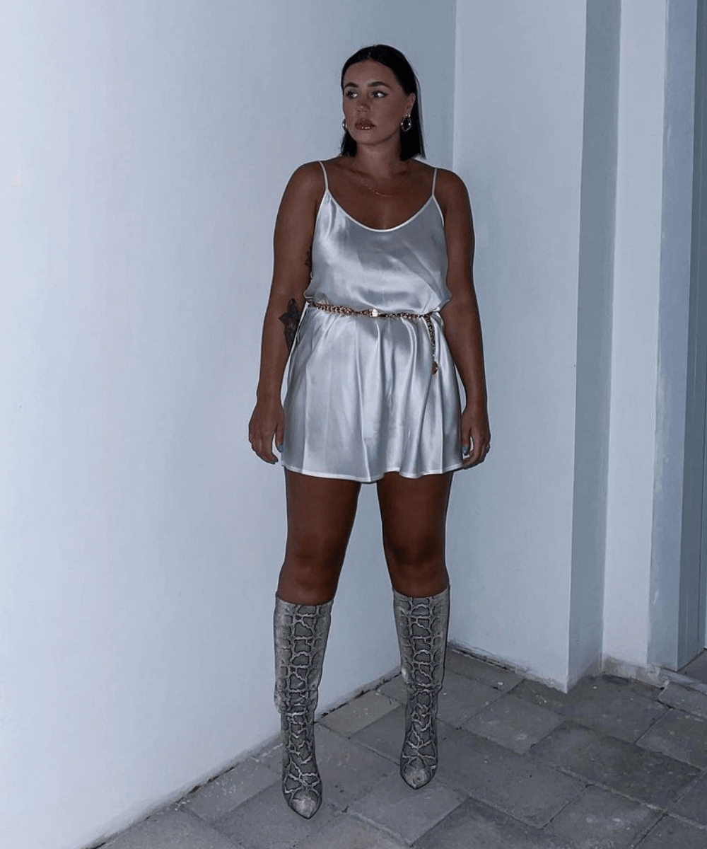 Grace Surguy - vestido acetinado e bota cobra - moda sem regras - Verão 2022 - em frente a uma parede - https://stealthelook.com.br