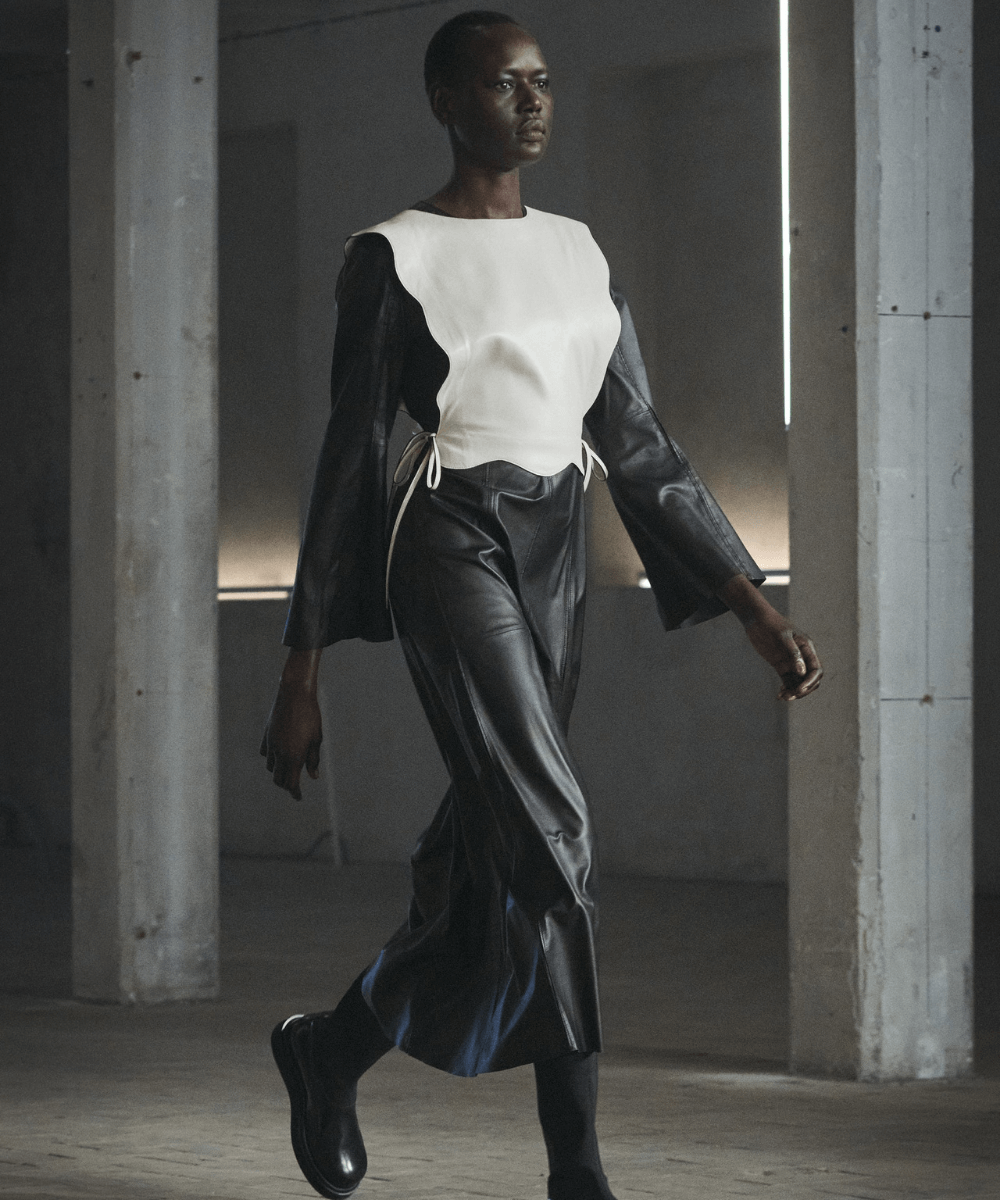 By Malena Birger - saia de couro preta, blusa preta com sobreposição branca e botas - semana de moda de Copenhagen - Outono - Copenhagen - https://stealthelook.com.br