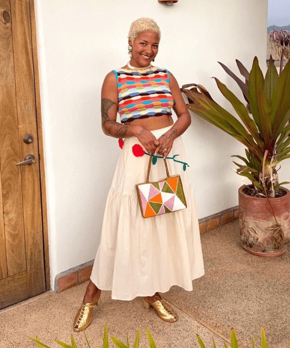Michelle Norris - cropped de crochê, saia midi e sapatos metalizados - blusa de crochê - verão - em pé na rua - https://stealthelook.com.br