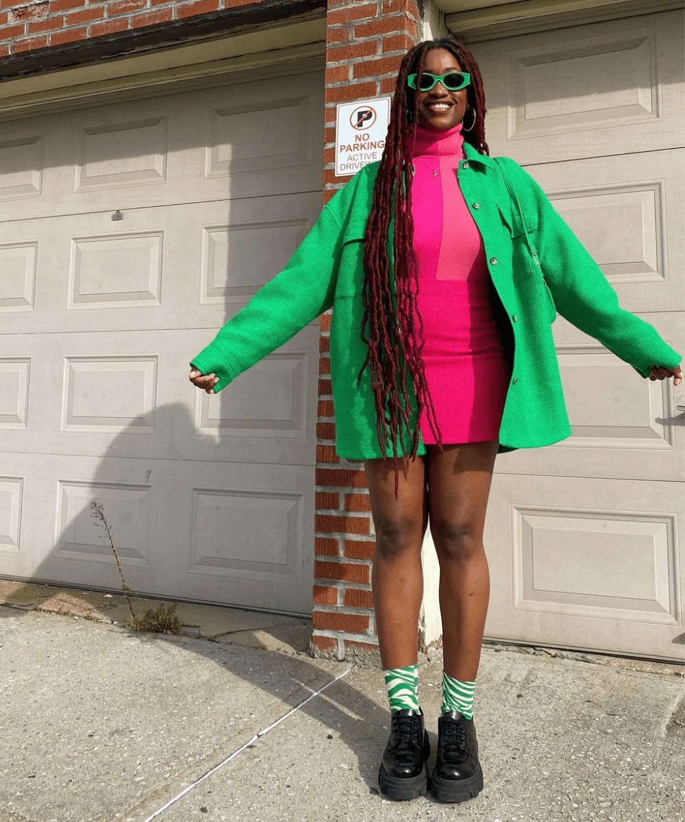 Yolande Macon - conjunto rosa com jaqueta verde - cores tendência - Verão 2022 - em frente a um portão - https://stealthelook.com.br