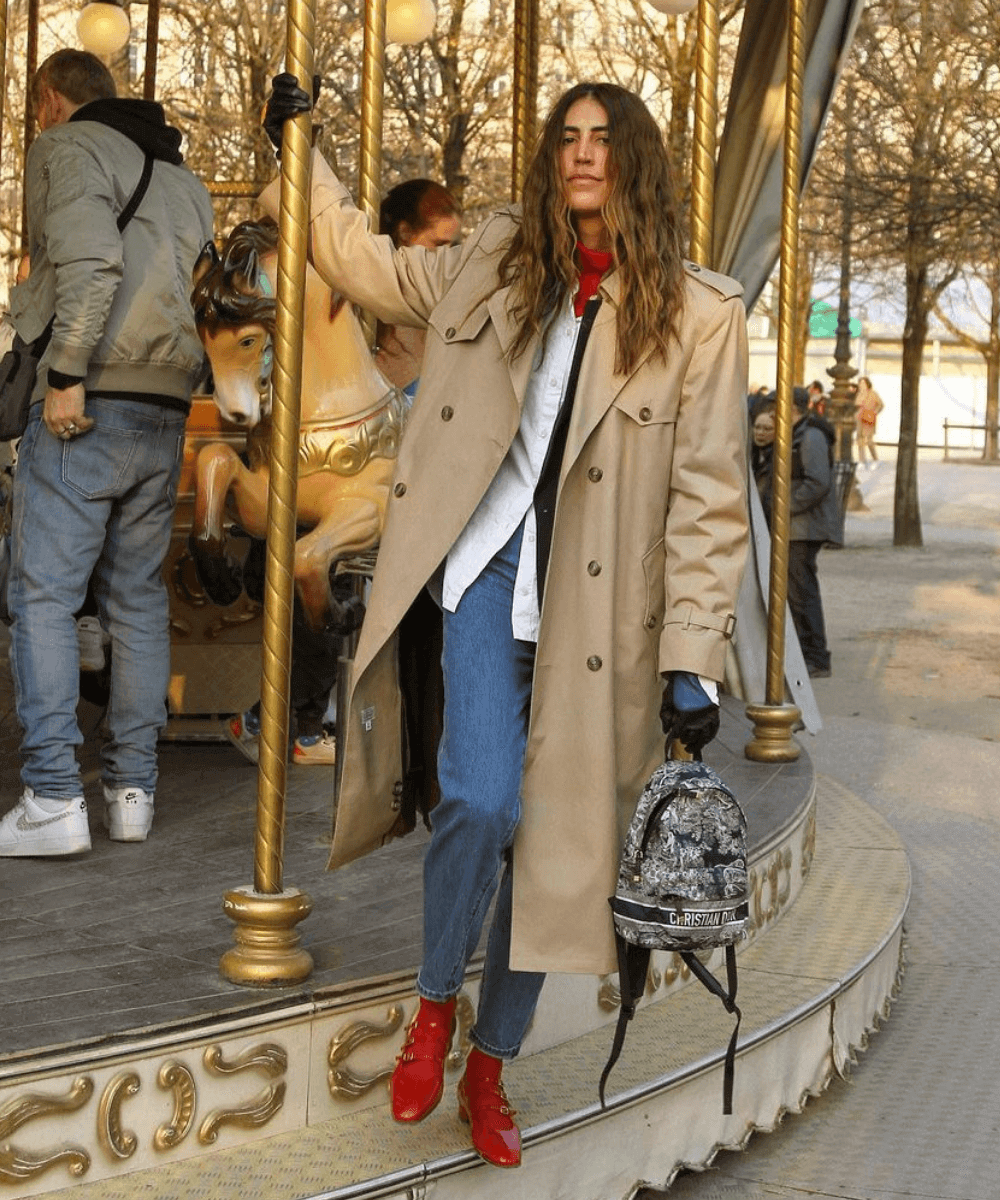 Thai Brufrem - calça jeans, camisa e trench coat com meias e sapatilha vermelha - semana de moda de Paris - Inverno  - Em pé segurando em um carrossel - https://stealthelook.com.br