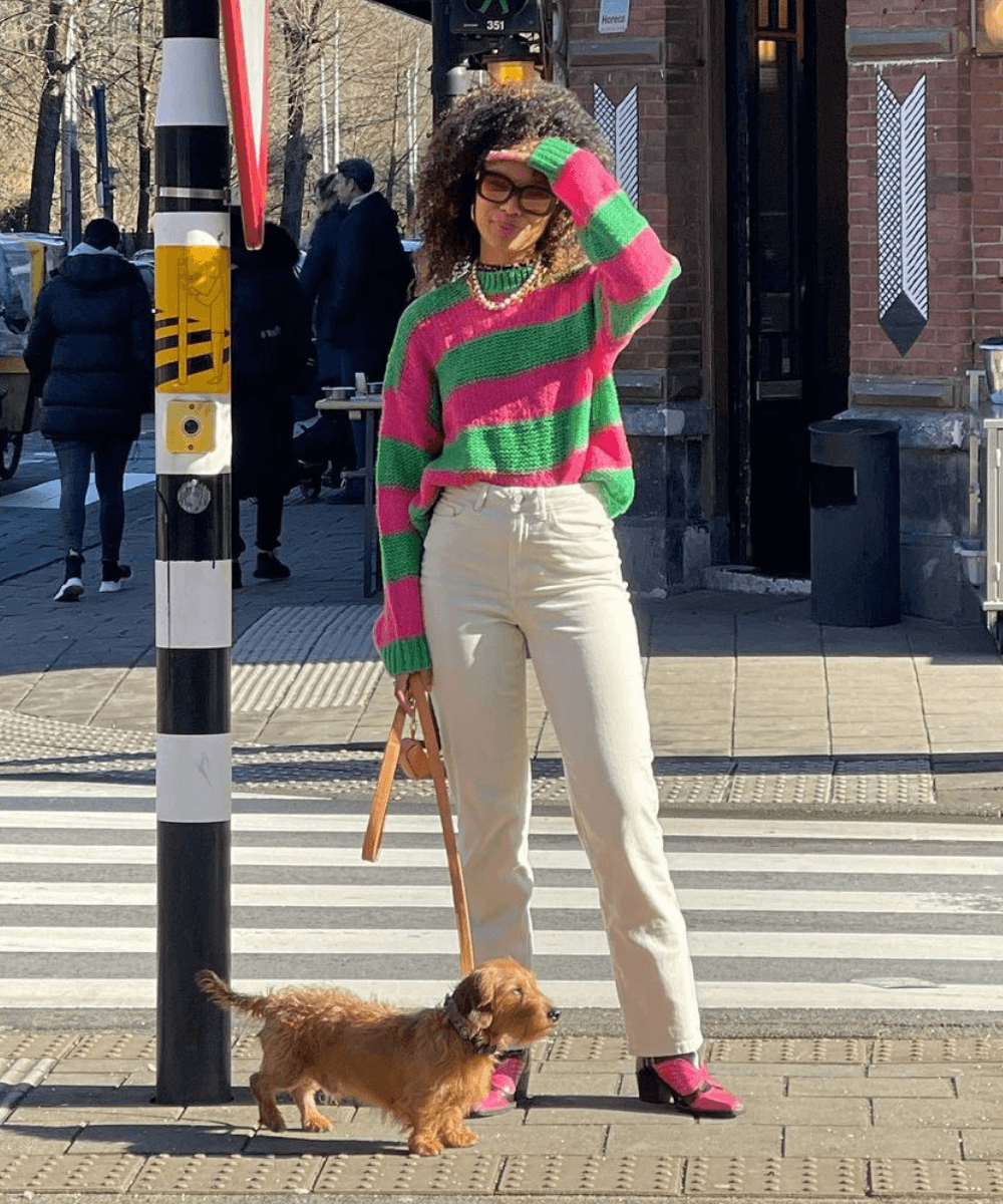 Fiah Hamelijnck - calça jeans, tricot listrado e tênis - dopamine dressing - Inverno  - em pé na rua com um cachorro do lado - https://stealthelook.com.br