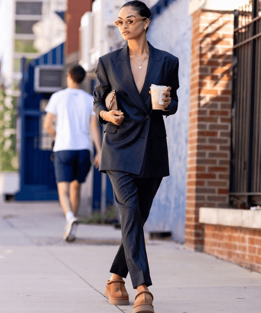 Shanina Shaik - terno preto e calçado ugg - inverno 2022 - Inverno  - andando na rua carregando um copo de café branco - https://stealthelook.com.br
