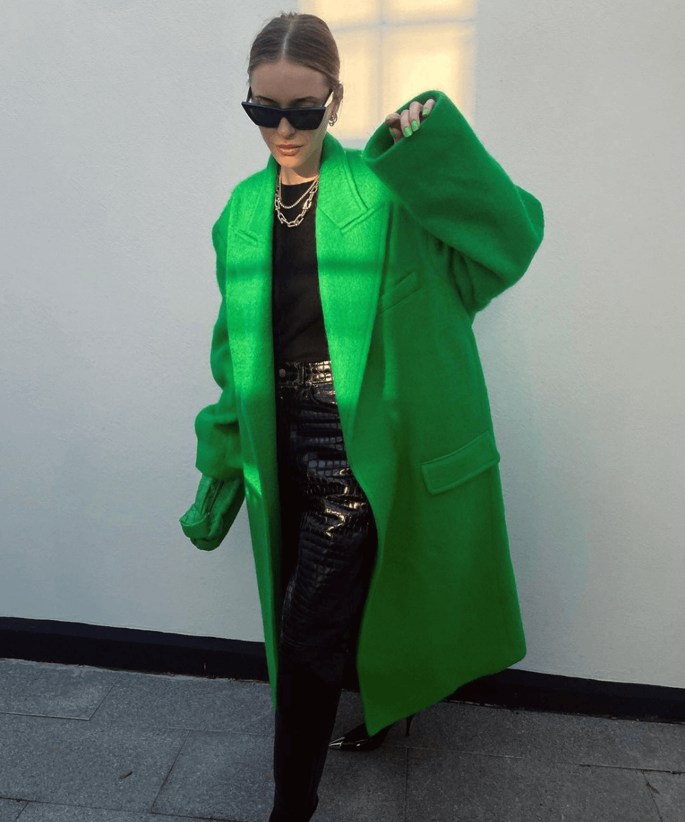 Pernille Teisbaek - calça de couro preta, blusa de manga longa preta, bota e casaco verde longo - outono 2022 - Outono - em pé na rua usando óculos de sol - https://stealthelook.com.br