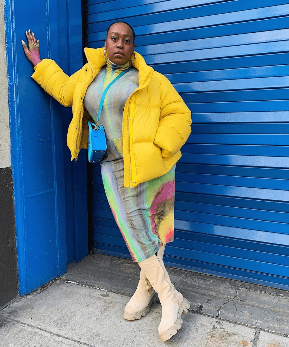 Aniyah Morinia - vestido longo estampado, jaqueta puffer amarela e botas brancas - outono 2022 - Outono - em pé na rua encostada em uma parede - https://stealthelook.com.br