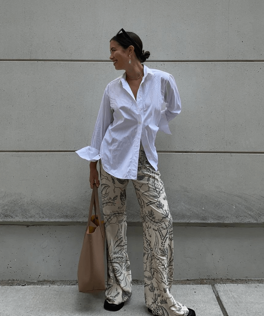 Sasha Mei - calça estampada ampla, camisa branca e chinelo - looks novos - Outono - em pé na rua olhando para o lado - https://stealthelook.com.br
