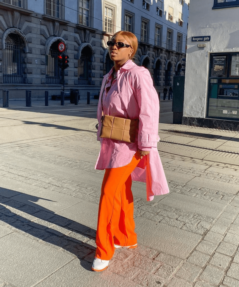 Nnenna Echem - Calça laranja, camisa oversized rosa e tênis branco - looks novos - Primavera - em pé na rua - https://stealthelook.com.br
