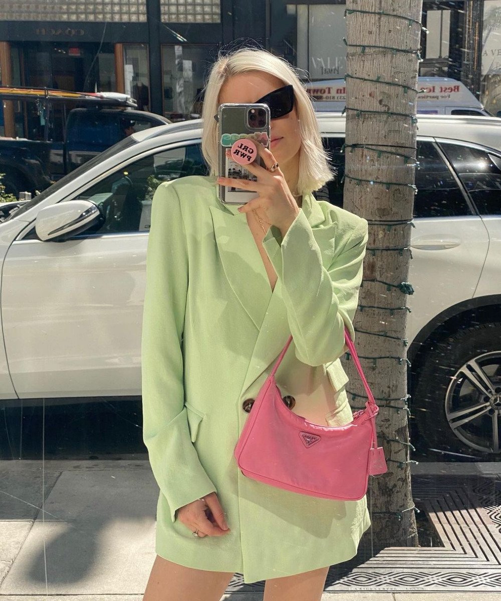 @lizbestmckay - blazer verde e bolsa rosa - bolsa da Prada - Verão - em pé na rua tirando foto em uma vitrine - https://stealthelook.com.br