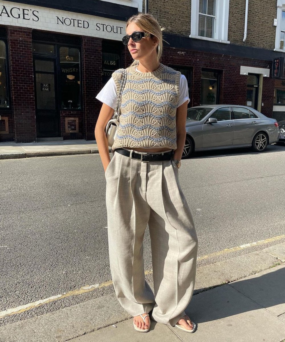 Camille Charriere - calça de alfaiataria, blusa branca e colete de tricô - calça de alfaiataria - Outono - em pé na rua usando óculos de sol - https://stealthelook.com.br