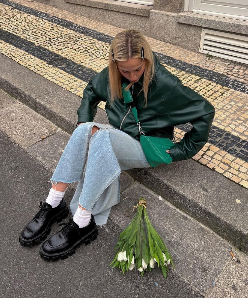 Sofia Coelho - saia jeans midi, jaqueta de couro verde e mocassim tratorado preto - inverno 2022 - Inverno  - sentada na rua - https://stealthelook.com.br