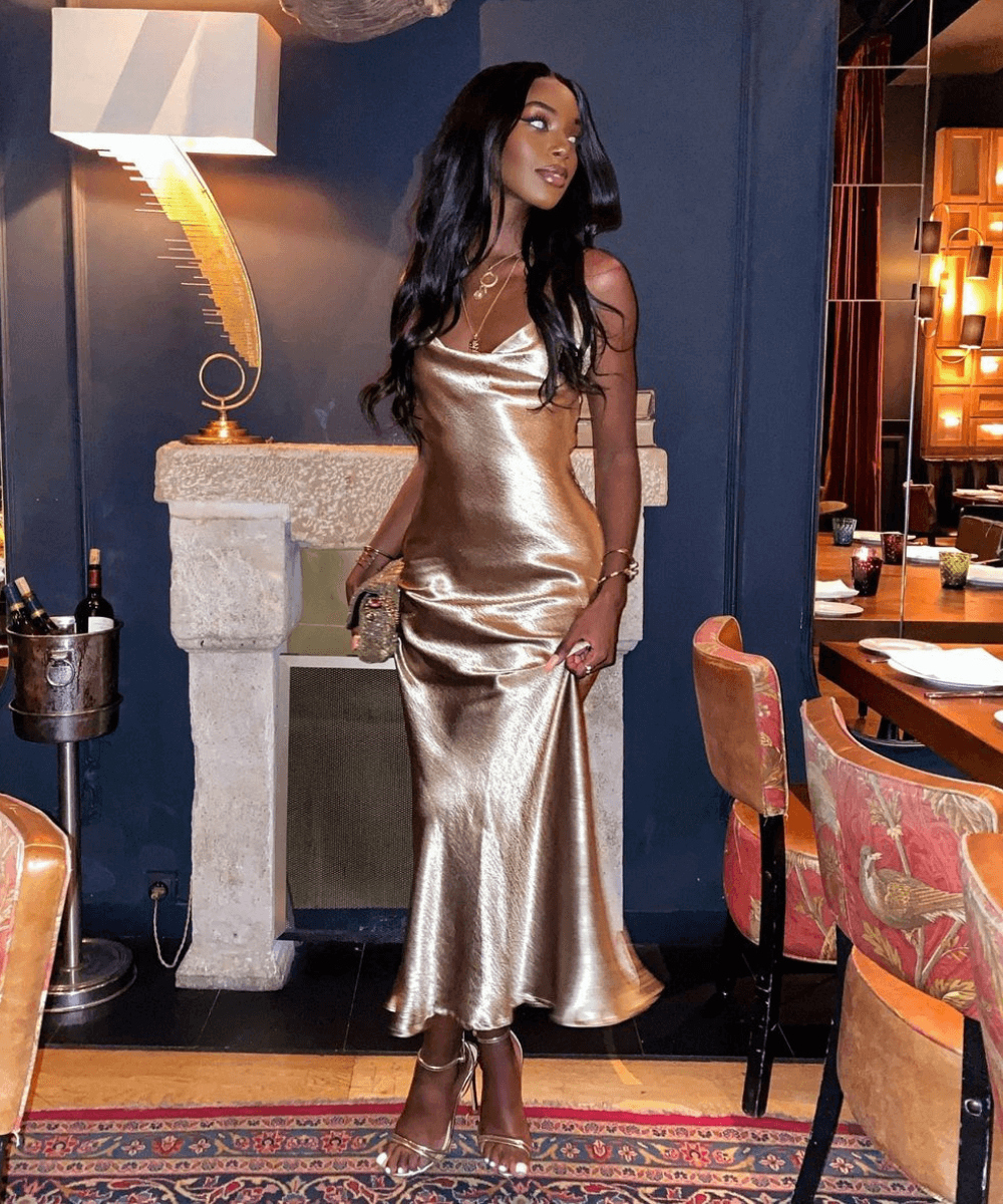 Anta Liya - vestido acetinado dourado - peças-chave versáteis - Inverno 2022 - em um restaurante - https://stealthelook.com.br