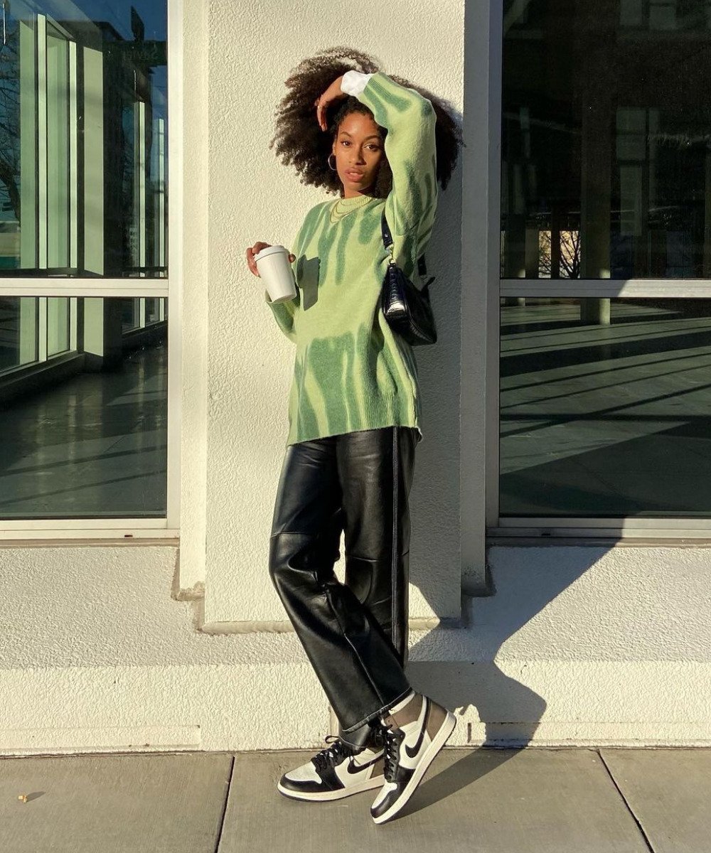Claire Most - calça de p.u preta, tênis jordan e tricô verde - tênis da moda - Inverno  - em pé na rua - https://stealthelook.com.br