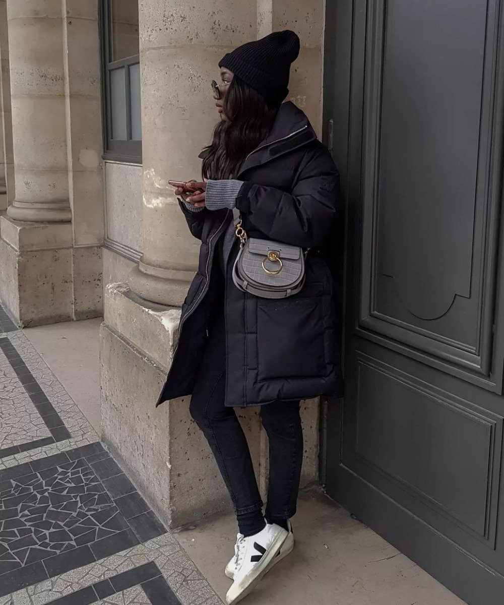 Aïda Badji Sané - look preto com jaqueta puffer, toca e tênis vert - tênis da moda - Inverno  - em pé na rua - https://stealthelook.com.br