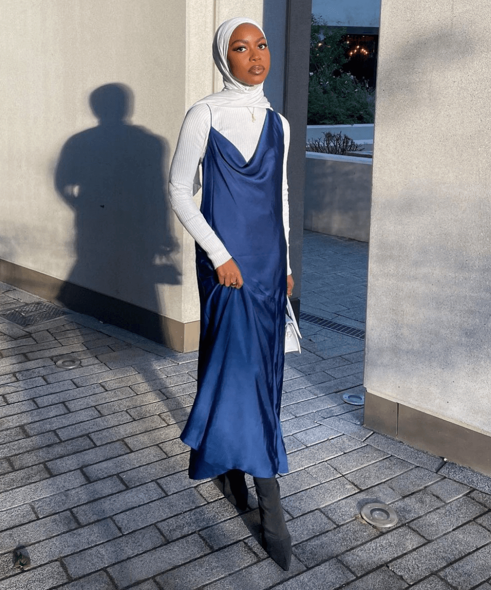 @aishaxahmada - slip dress azul, blusa branca e bota preta - looks novos - Outono - em pé na rua - https://stealthelook.com.br