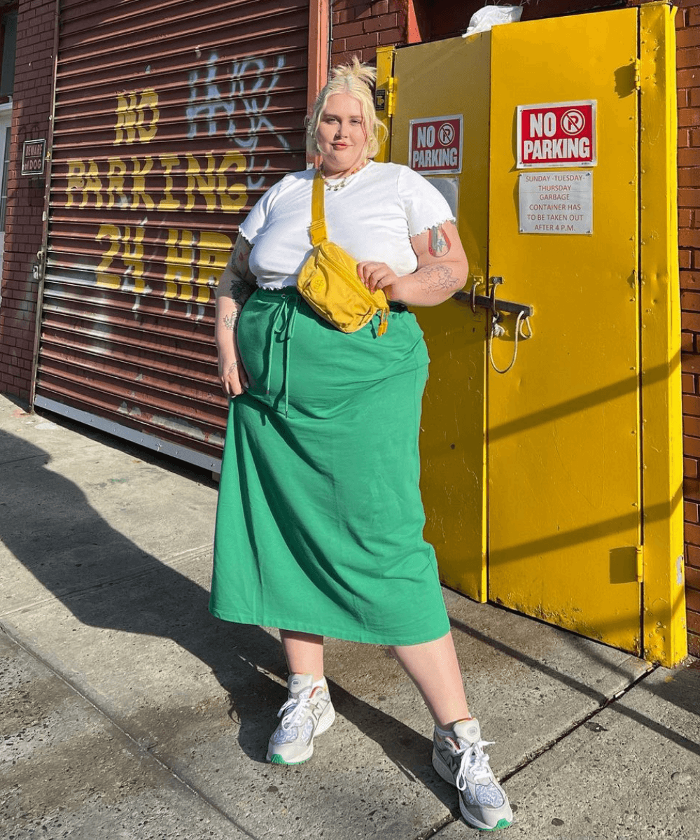 Abby Bible - saia verde, t-shirt branca e bolsa amrela - looks novos - Verão - em pé na rua - https://stealthelook.com.br