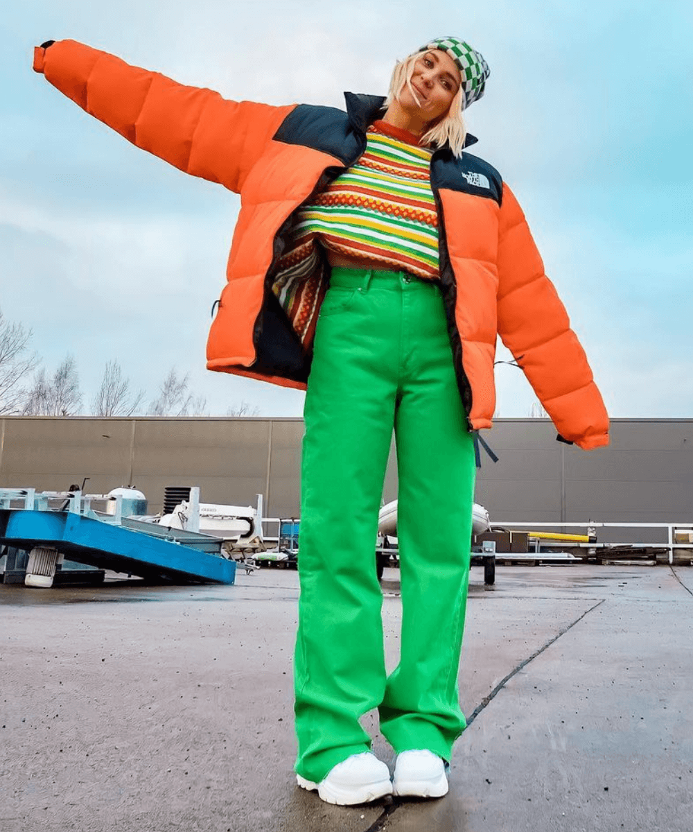 @lauraintechnicolor - puffer jackets laranja com calça verde e blusa de tricô - puffer jackets - Inverno 2022 - na rua - https://stealthelook.com.br