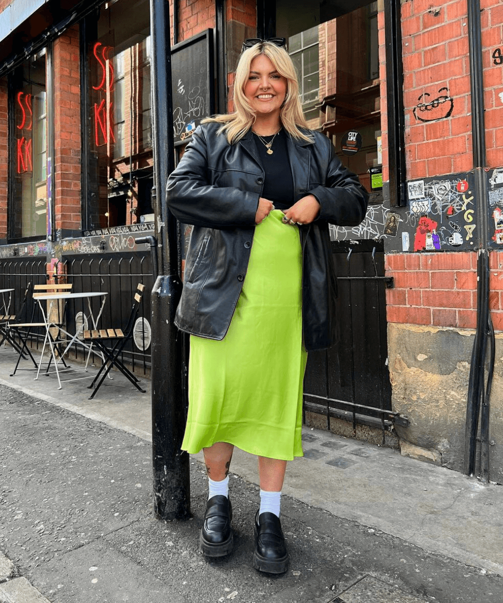 Libby Faulkner - blusa preta com jaqueta de couro e saia verde limão com mocassim tratorado - sapatos confortáveis - Inverno 2022 - na rua - https://stealthelook.com.br