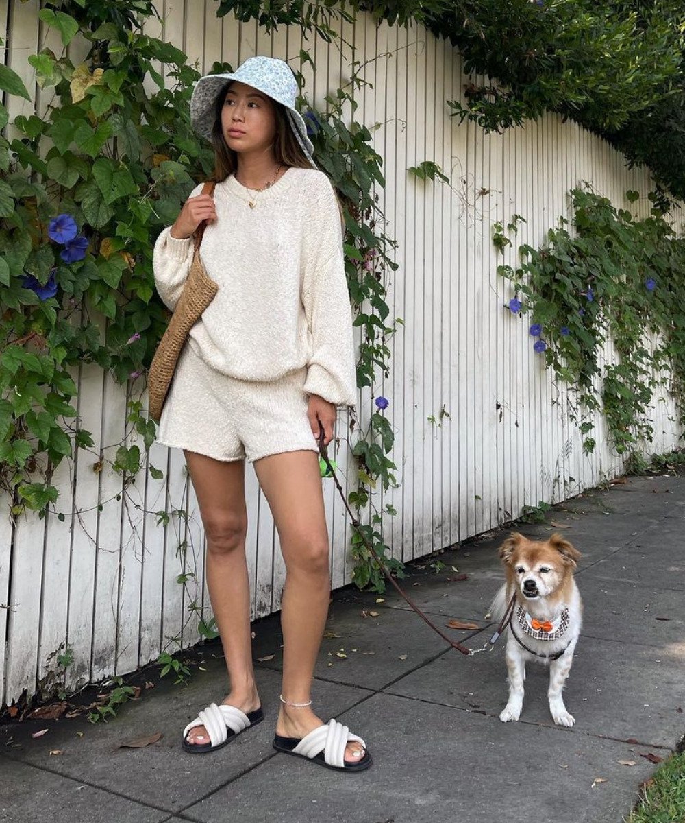 Aimee Song - conjunto de tricô off white e bucket hat - moda inverno 2022 - Inverno  - em pé na rua com um cachorro do lado - https://stealthelook.com.br