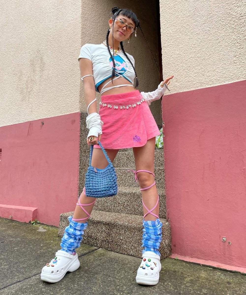 Tara Chandra - minissaia rosa, tshirt, luvas e crocs de plataforma - maximalismo meta - verão - em pé na rua - https://stealthelook.com.br