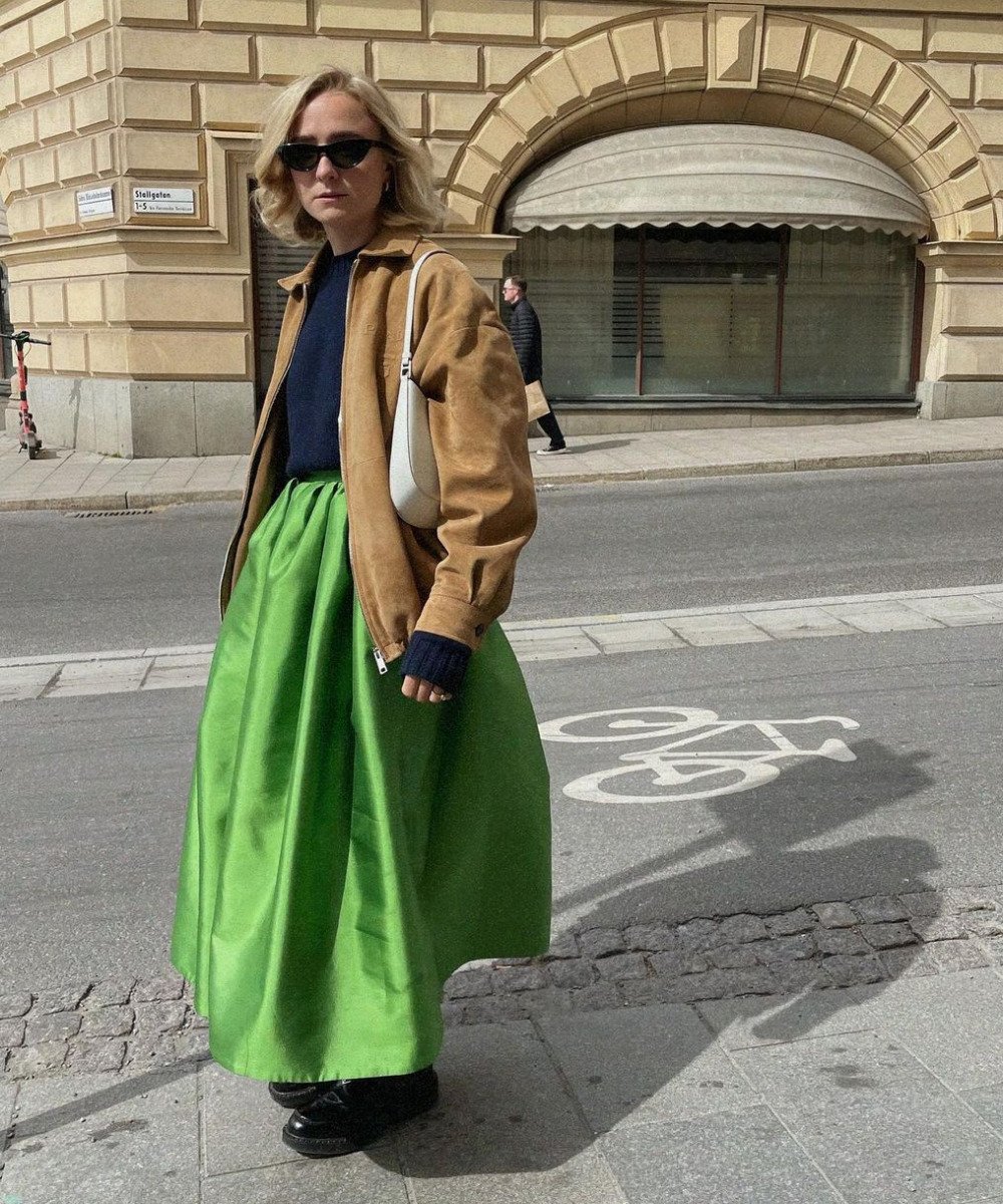 Fanny Ekstrand Tourneur - saia longa verde, jaqueta e loafer preto - saia da Prada - Inverno  - em pé na rua usando óculos de sol - https://stealthelook.com.br