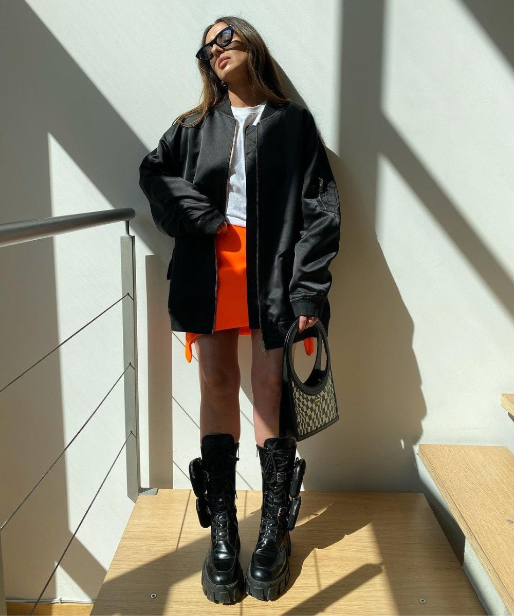 Laura Eguizabal - minissaia laranja, coturno preto prada e jaqueta de couro - saia da Prada - Outono - em pé na casa  - https://stealthelook.com.br