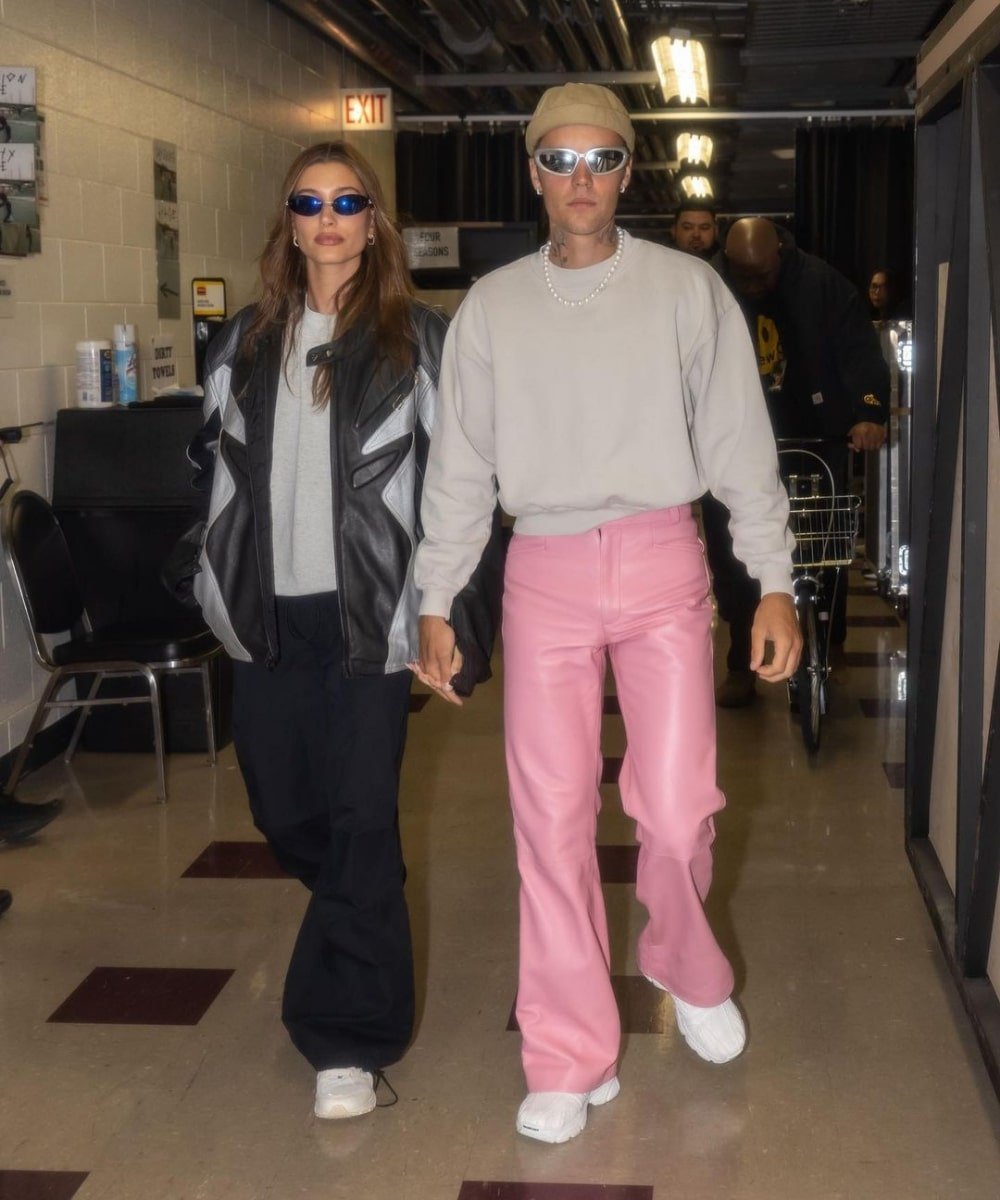 Justin e Hailey Bieber - calça rosa, moletom cinza e óculos. - Hailey e Justin Bieber - Verão - andando juntos de mãos dadas e sorrindo - https://stealthelook.com.br
