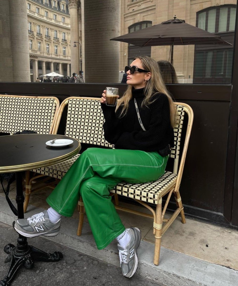 Olivia Faeh - calça verde de p.u, trico preto e tênis - looks novos - Outono - sentada em um café - https://stealthelook.com.br