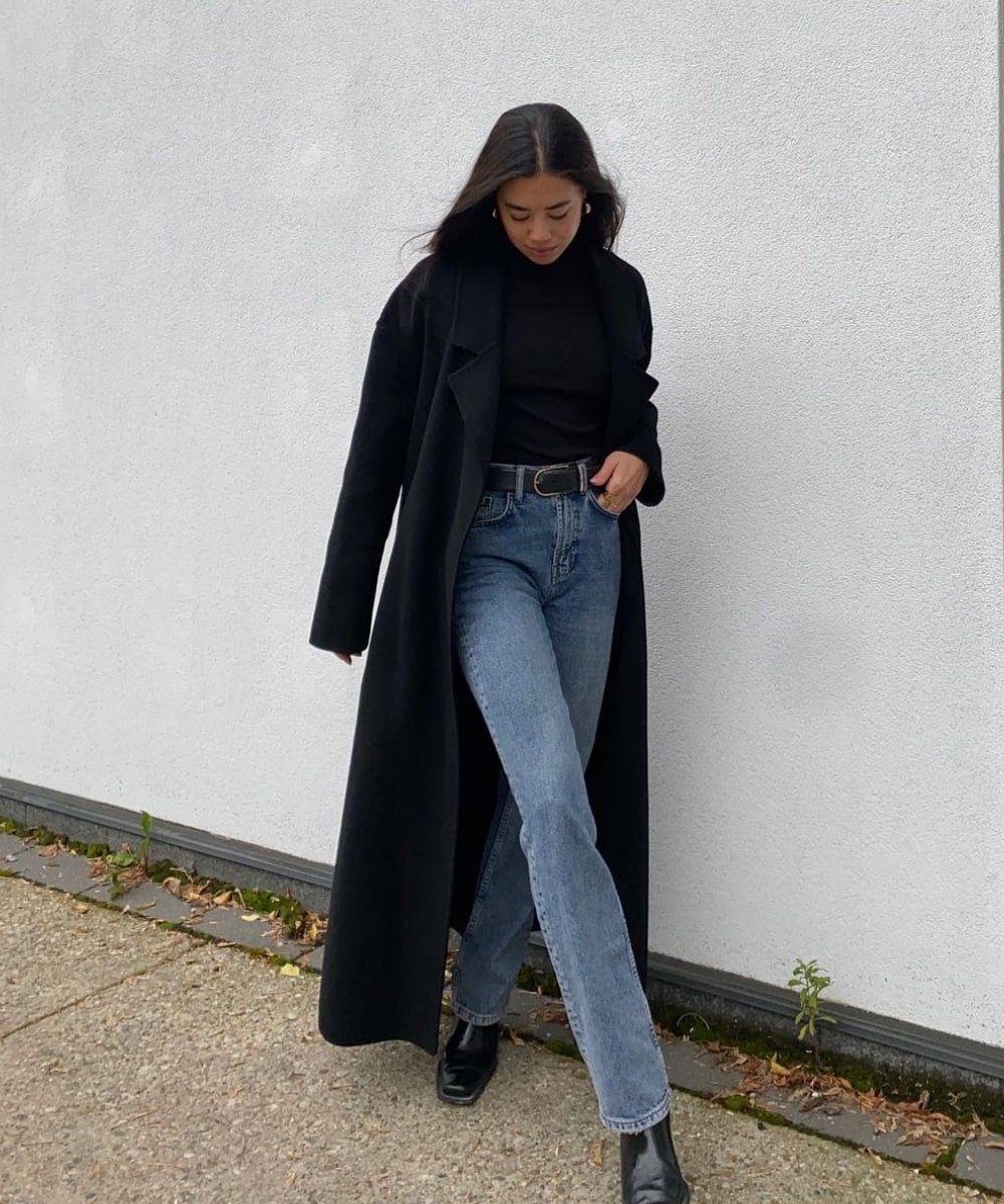 Sasha Mei - calça jeans, bota preta, tirco de gola alta e sobretudo - dia dos namorados - Inverno  - em pé na rua - https://stealthelook.com.br