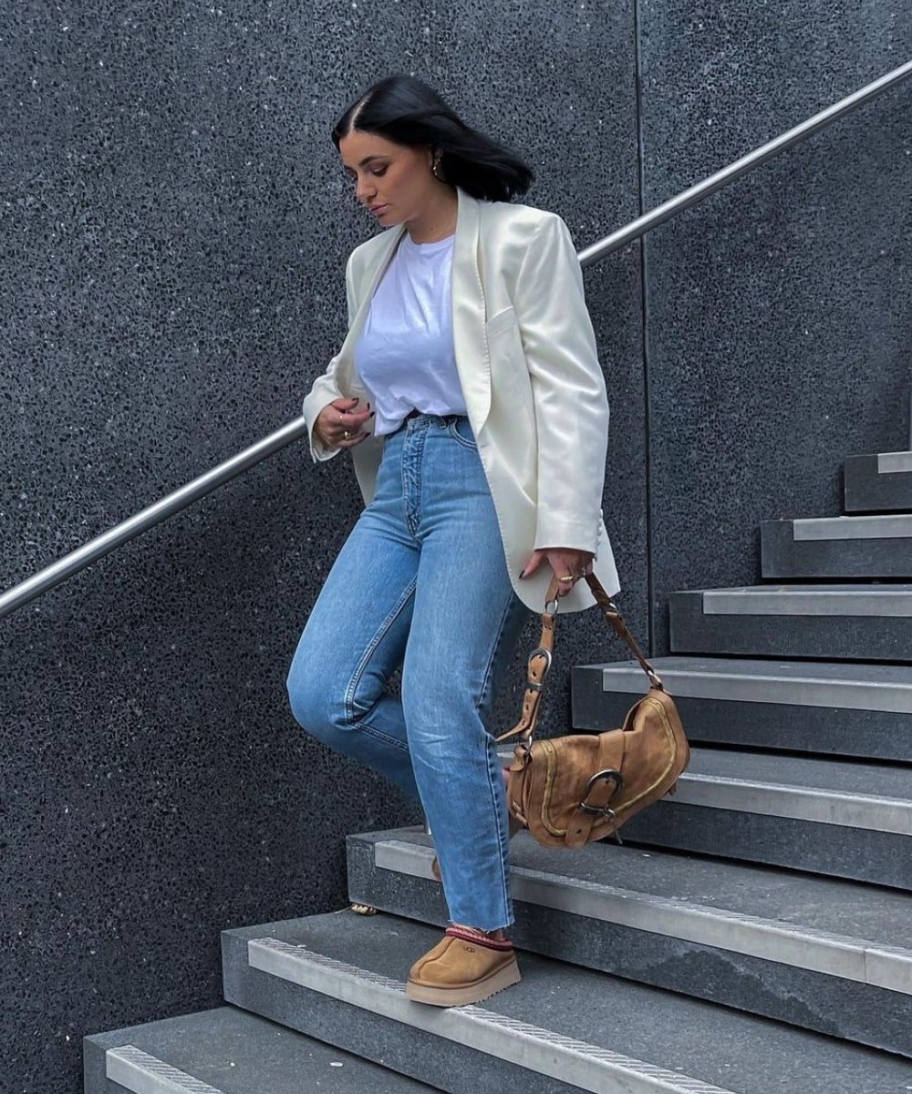 Grace Surguy - calça jeans, t-shirt branca, blazer e uggs - looks com bota ugg - Outono - descendo uma escada - https://stealthelook.com.br