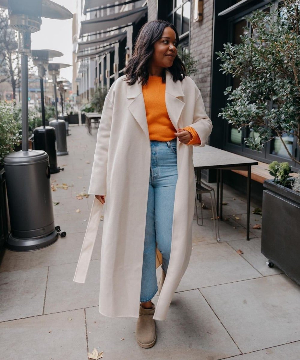 @styleidealist - blusa laranja, trench coat, calça jeans e uggs - looks com bota ugg - Outono - andando na rua - https://stealthelook.com.br